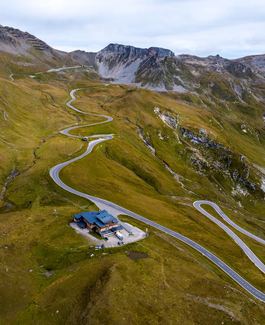 A mountain road winding upward through the Alps